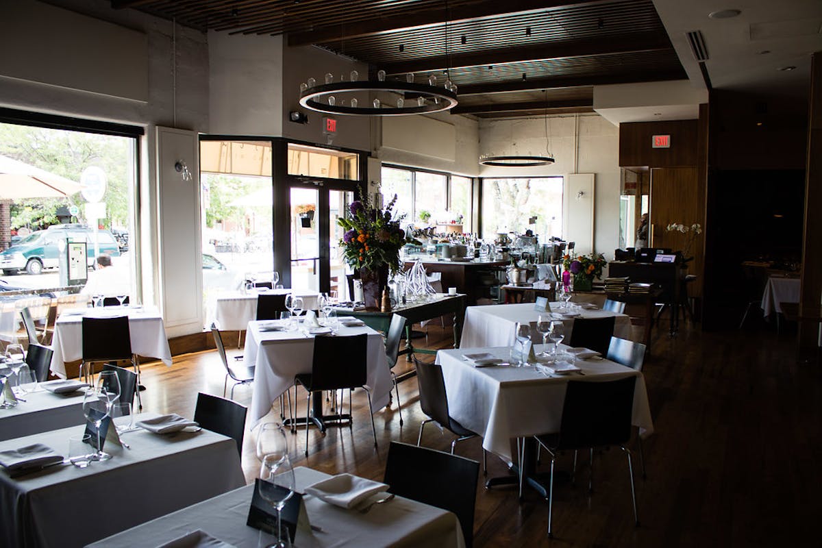 a dining room filled with furniture in front of a window